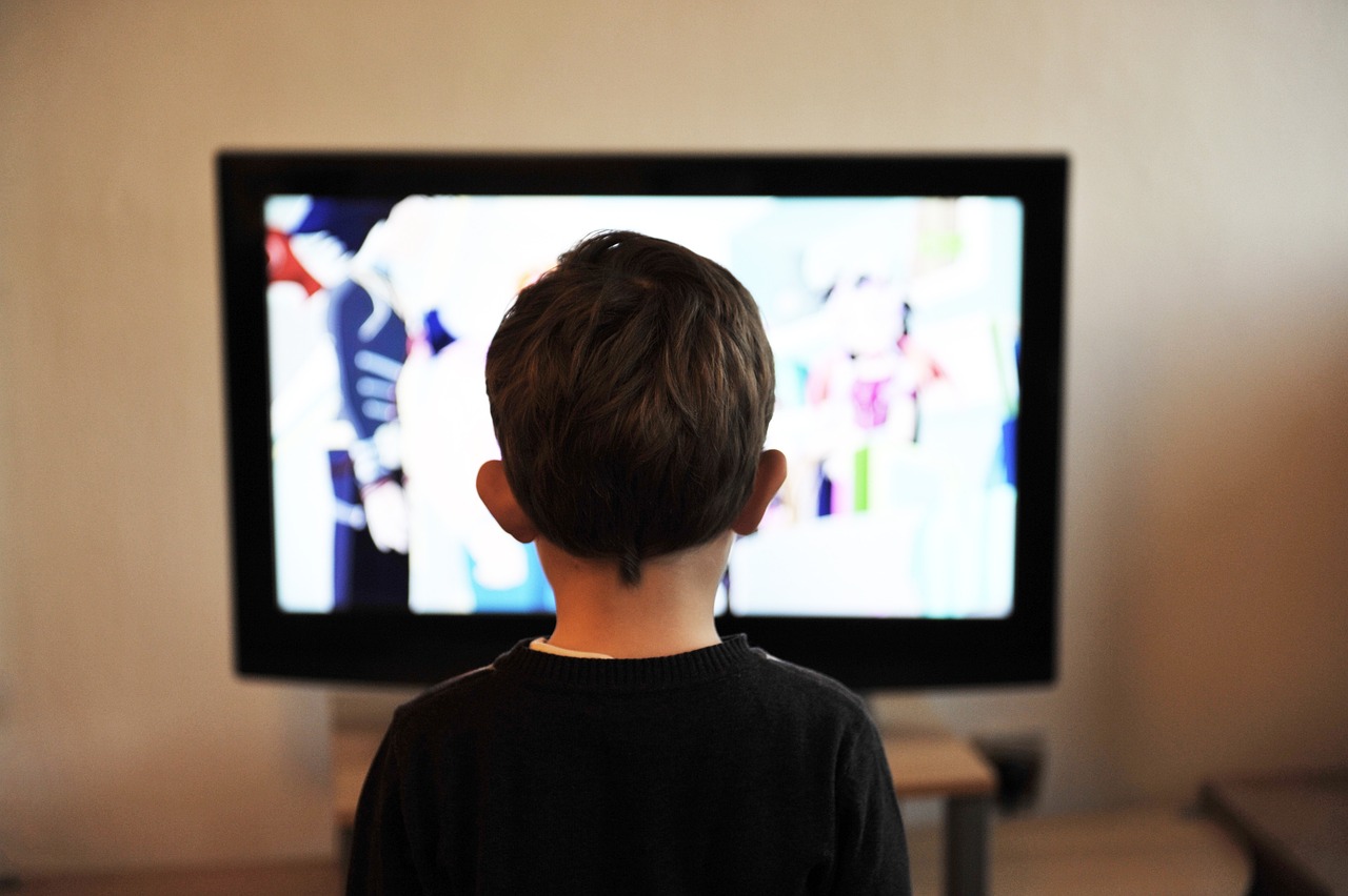 Kind steht vor dem Fernseher